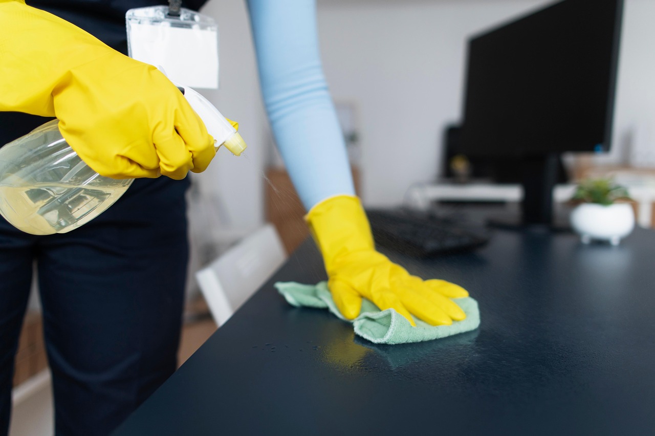 cleaning office desk wiping disinfecting